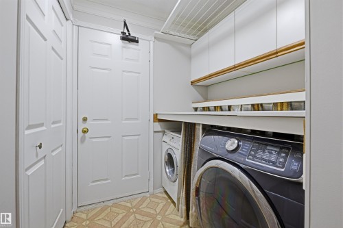 Laundry area featuring white cabinetry, a built-in countertop, and patterned flooring - 131 Walsh Crescent, Edmonton, AB - Indoor Photo Showing Laundry Room