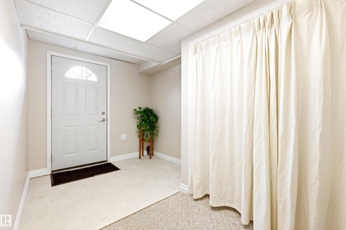 Entryway with a white door featuring an arched window, light-colored walls, and a dropped ceiling with recessed lighting - 131 Walsh Crescent, Edmonton, AB - Indoor Photo Showing Other Room