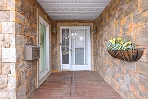 The property features a stone facade, a covered entry, and exterior lighting fixtures - 131 Walsh Crescent, Edmonton, AB - Outdoor With Exterior