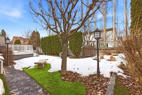 The property features an extensive yard with a paved walkway, a stone bench, and an outdoor light fixture - 131 Walsh Crescent, Edmonton, AB - Outdoor
