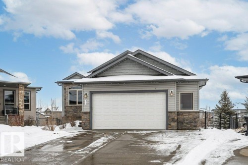 The property features a two-car garage, a stone and siding exterior, and a paved driveway - 33 Hillcrest Point(E), Fort Saskatchewan, AB - Outdoor