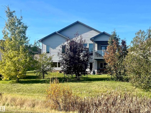 The property features a two-story exterior with light gray siding, complemented by a balcony and a lower patio area - 33 Hillcrest Point(E), Fort Saskatchewan, AB - Outdoor