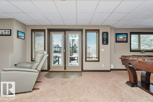 This room features neutral-toned walls and plush carpeting, complemented by multiple windows with blinds for natural light - 33 Hillcrest Point(E), Fort Saskatchewan, AB - Indoor Photo Showing Other Room