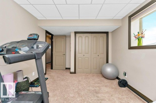 This versatile space features carpeting, a window providing natural light, and a drop ceiling - 33 Hillcrest Point(E), Fort Saskatchewan, AB - Indoor