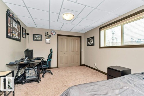 This room features carpeted flooring, neutral-toned walls, and a window with a brown trim - 33 Hillcrest Point(E), Fort Saskatchewan, AB - Indoor