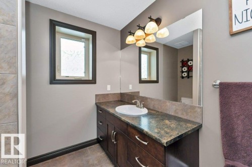 This bathroom features a dark wood vanity with a light-colored countertop and an integrated sink - 33 Hillcrest Point(E), Fort Saskatchewan, AB - Indoor Photo Showing Bathroom
