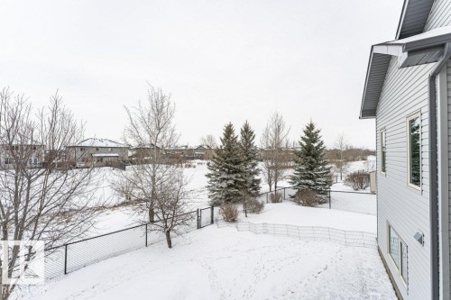 The property includes a spacious yard with a fence, mature trees, and a view of surrounding residences - 33 Hillcrest Point(E), Fort Saskatchewan, AB - Outdoor