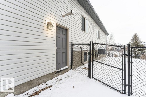 The property features exterior siding, a secure gate, and an outdoor light fixture - 33 Hillcrest Point(E), Fort Saskatchewan, AB - Outdoor With Exterior