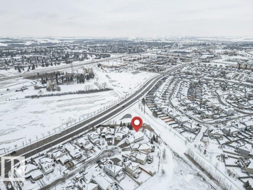 Aerial view of the property and its surrounding neighborhood, featuring residential streets, houses with snow-covered rooftops, and nearby roads - 33 Hillcrest Point(E), Fort Saskatchewan, AB - Outdoor With View