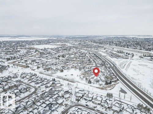 Aerial view of the surrounding residential area, featuring houses with snow-covered roofs and a visible road network - 33 Hillcrest Point(E), Fort Saskatchewan, AB - Outdoor With View