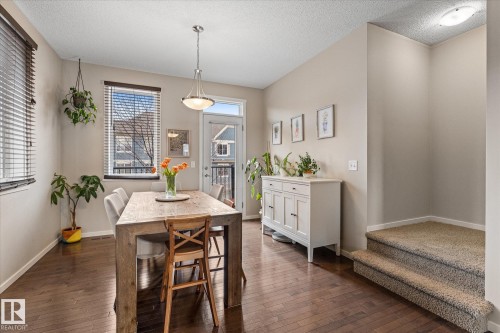 The dining area features hardwood flooring, a pendant light fixture, and windows with blinds for natural light - 165 603 Watt Boulevard, Edmonton, AB - Indoor Photo Showing Dining Room