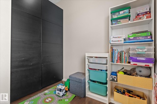 This room features hardwood flooring and a built-in white shelving unit - 165 603 Watt Boulevard, Edmonton, AB - Indoor Photo Showing Other Room