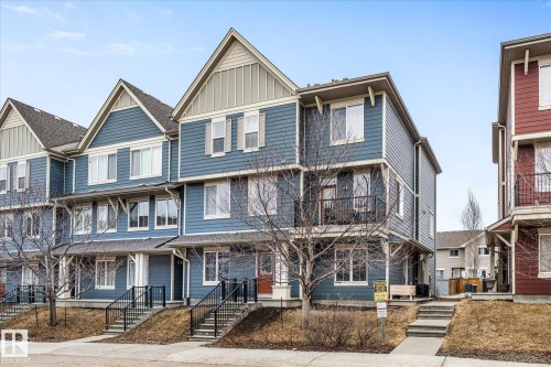 The property features a three-story exterior with blue siding and white trim, complemented by a gray shingled roof - 165 603 Watt Boulevard, Edmonton, AB - Outdoor With Facade