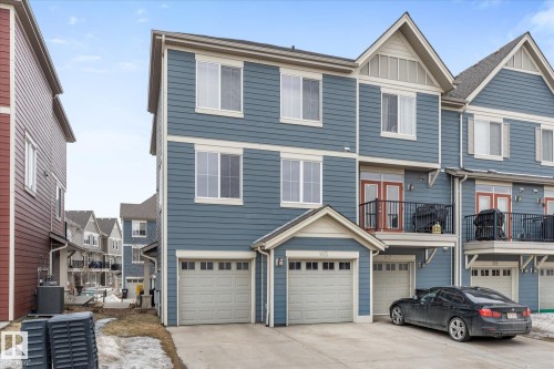 The property features blue siding with white trim, an attached garage, and a balcony with a black railing - 165 603 Watt Boulevard, Edmonton, AB - Outdoor With Facade