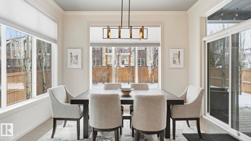 This dining area features large windows with blinds, a modern light fixture, and a sliding glass door - 131 North Ridge Drive, St. Albert, AB - Indoor Photo Showing Dining Room