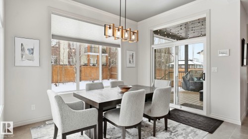 Dining space with large windows and a glass sliding door providing access to an outdoor deck - 131 North Ridge Drive, St. Albert, AB - Indoor Photo Showing Dining Room