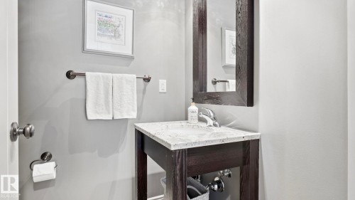 This bathroom features a contemporary vanity with a chrome faucet, a framed mirror, and light gray walls - 131 North Ridge Drive, St. Albert, AB - Indoor Photo Showing Bathroom