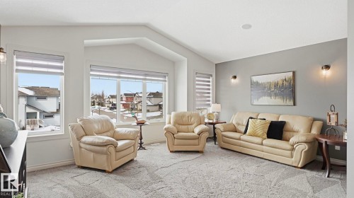 The living area features a vaulted ceiling, large windows with blinds, and light-toned carpeting - 131 North Ridge Drive, St. Albert, AB - Indoor Photo Showing Living Room