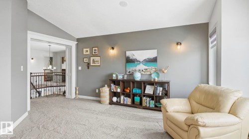 This space features carpeted flooring, a neutral wall color, and wall sconces providing ambient lighting - 131 North Ridge Drive, St. Albert, AB - Indoor