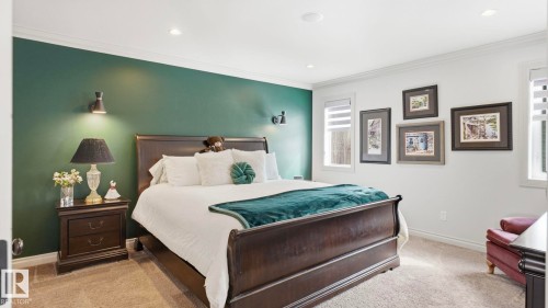 This bedroom features a striking green accent wall, white walls, and light-colored carpeting, creating a sophisticated aesthetic - 131 North Ridge Drive, St. Albert, AB - Indoor Photo Showing Bedroom