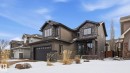 The property features a dark-toned exterior with siding and stone accents, a prominent front entrance with a covered porch, and a double-door garage - 131 North Ridge Drive, St. Albert, AB  - Outdoor With Facade 