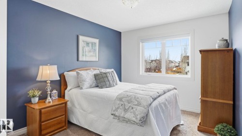 This room features a window providing natural light, carpeted flooring, and a blue accent wall - 131 North Ridge Drive, St. Albert, AB - Indoor Photo Showing Bedroom