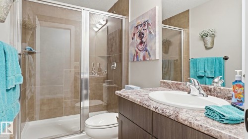 Bathroom featuring a white vanity with a light-colored countertop, a chrome faucet, and a shower with glass doors and tiled walls - 131 North Ridge Drive, St. Albert, AB - Indoor Photo Showing Bathroom