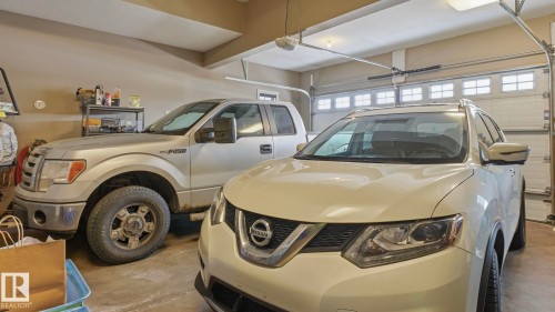 The property features a spacious garage with a light-colored concrete floor and a garage door with window inserts - 131 North Ridge Drive, St. Albert, AB - Indoor Photo Showing Garage