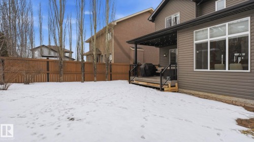 The property features a spacious yard with a wooden fence and tall, slender trees - 131 North Ridge Drive, St. Albert, AB - Outdoor With Exterior