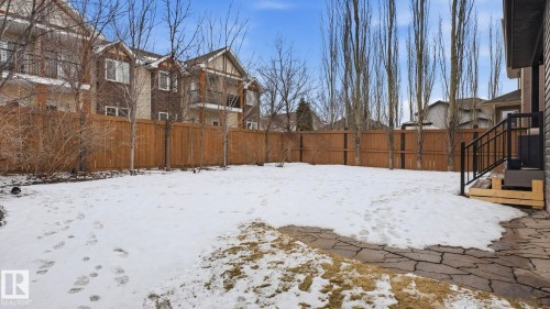 The property features a private yard enclosed by a wooden fence, with a paved patio area leading to an exterior staircase - 131 North Ridge Drive, St. Albert, AB - Outdoor
