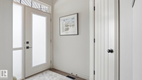 Inviting entryway featuring a white door with frosted glass, a side panel with frosted glass, and a transom window with decorative grilles - 131 North Ridge Drive, St. Albert, AB - Indoor Photo Showing Other Room
