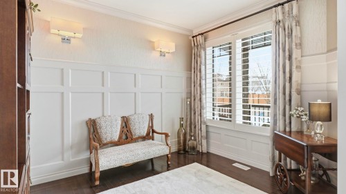This interior space features dark hardwood floors and wainscoting on the lower walls, complemented by light-colored wallpaper on the upper walls - 131 North Ridge Drive, St. Albert, AB - Indoor Photo Showing Other Room