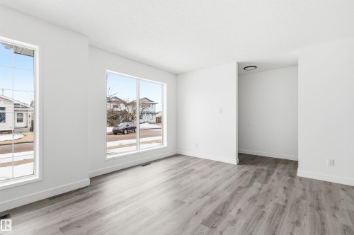 The interior space features light-colored walls and grey wood-look flooring - 16223 55A Street, Edmonton, AB - Indoor Photo Showing Other Room