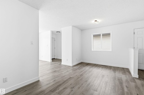 The property features light-colored plank flooring, white walls, and a window with horizontal blinds - 16223 55A Street, Edmonton, AB - Indoor Photo Showing Other Room