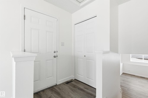 Entryway featuring light-colored flooring, a white paneled door, and a white bi-fold closet door - 16223 55A Street, Edmonton, AB - Indoor Photo Showing Other Room