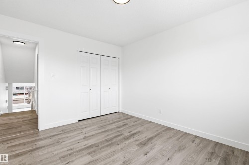 This room features light-colored plank flooring, white walls, and a ceiling light fixture - 16223 55A Street, Edmonton, AB - Indoor Photo Showing Other Room