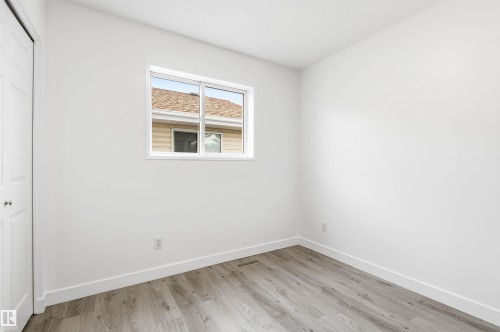 This room features a window providing natural light, light-toned walls, and wood-style flooring - 16223 55A Street, Edmonton, AB - Indoor Photo Showing Other Room