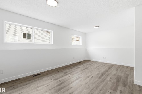 This room features wood-look flooring and white walls, creating a bright and airy atmosphere - 16223 55A Street, Edmonton, AB - Indoor Photo Showing Other Room