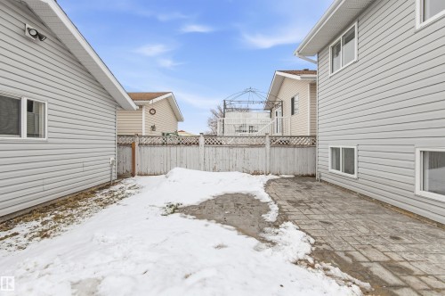 The property features a fenced yard with both a paved section and a snow-covered area - 16223 55A Street, Edmonton, AB - Outdoor With Exterior
