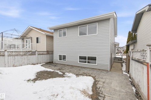 The property features light gray siding and white trim, with a paved patio area - 16223 55A Street, Edmonton, AB - Outdoor With Exterior
