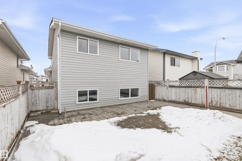 The property features grey siding and white-framed windows, with a paved patio area - 16223 55A Street, Edmonton, AB - Outdoor With Exterior