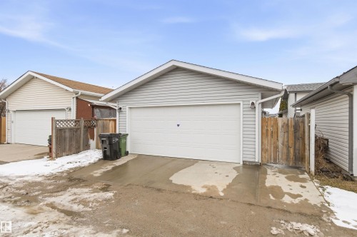 The property features a detached garage with light-colored siding and a white garage door - 16223 55A Street, Edmonton, AB - Outdoor With Exterior