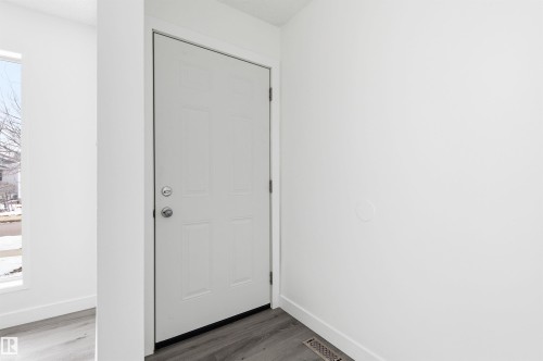 Entryway featuring a white paneled door with brushed nickel hardware, light wood-style flooring, and a window providing natural light - 16223 55A Street, Edmonton, AB - Indoor Photo Showing Other Room