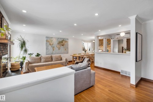 The main living area showcases hardwood flooring and recessed lighting, with a view towards the dining area - 4208 89 Street Nw, Edmonton, AB - Indoor Photo Showing Living Room