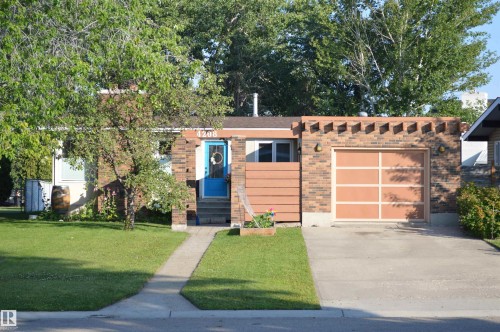 The property features a brick exterior, a driveway, and an attached garage - 4208 89 Street Nw, Edmonton, AB - Outdoor