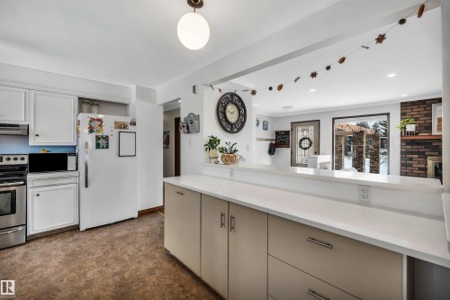 Kitchen with white cabinetry, stainless steel appliances, and a tiled backsplash - 4208 89 Street Nw, Edmonton, AB - Indoor Photo Showing Kitchen