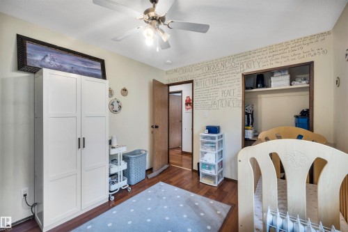 This room features hardwood flooring, light-colored walls, and a ceiling fan with an integrated light fixture - 4208 89 Street Nw, Edmonton, AB - Indoor