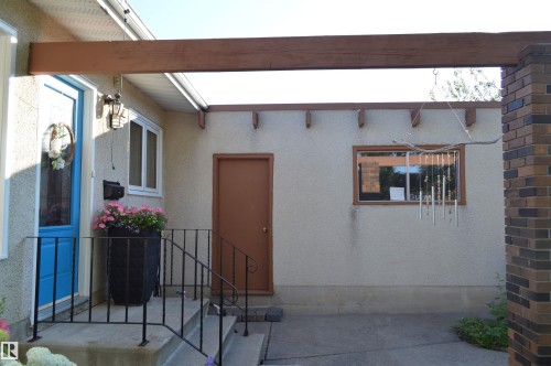 The property features a concrete walkway leading to an entryway with concrete steps and a wrought iron railing - 4208 89 Street Nw, Edmonton, AB - Outdoor With Exterior
