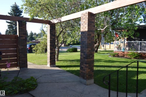 The property features a concrete pathway with brick pillars and an overhead beam - 4208 89 Street Nw, Edmonton, AB - Outdoor