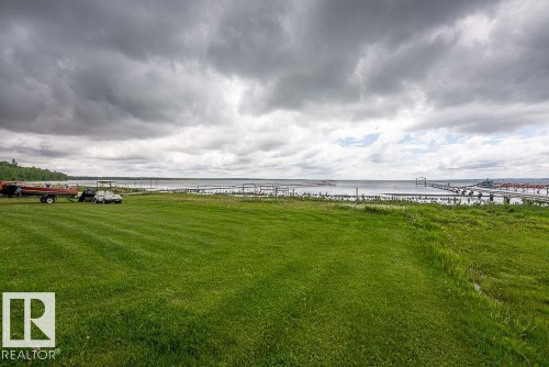 Expansive waterfront property featuring a large grassy lawn and direct water access - 90 2001 Twp Rd, Rural Leduc County, AB 